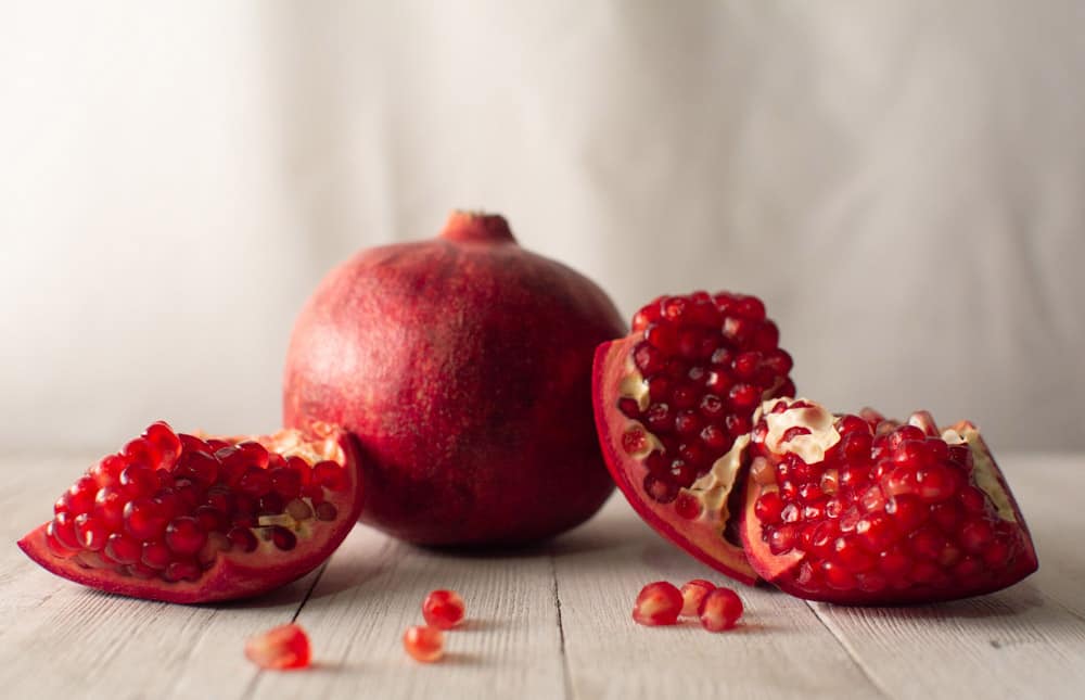 picture of a whole pomegranate and cut up pomegranate