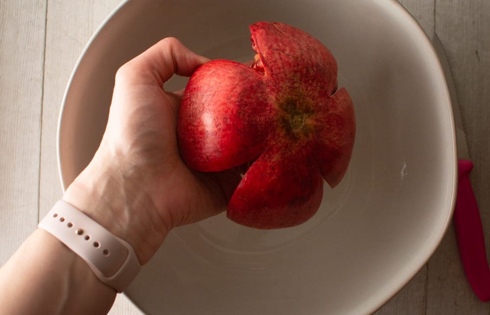 Holding pomegranate over bowl