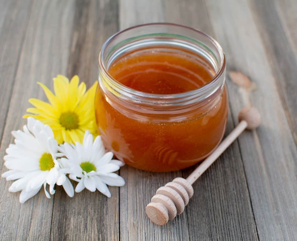 Jar of honey on wood board
