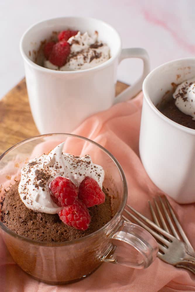 three mugs of chocolate cake on pink background