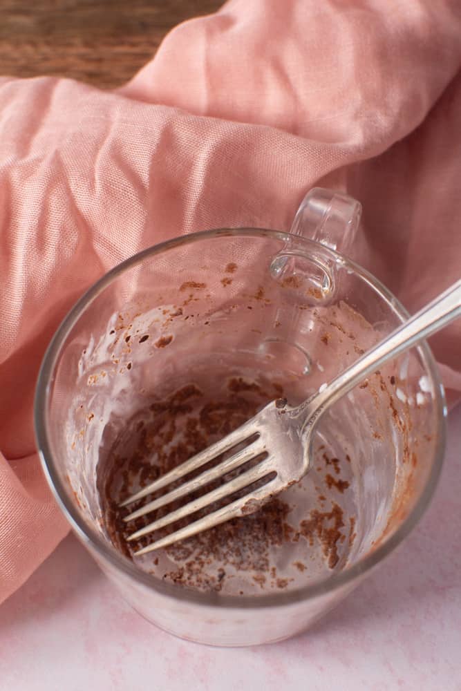 empty mug with chocolate cake crumbs and fork