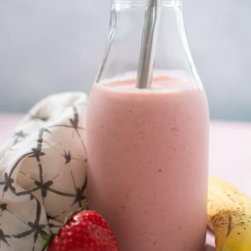 Pink smoothie in glass with metal straw
