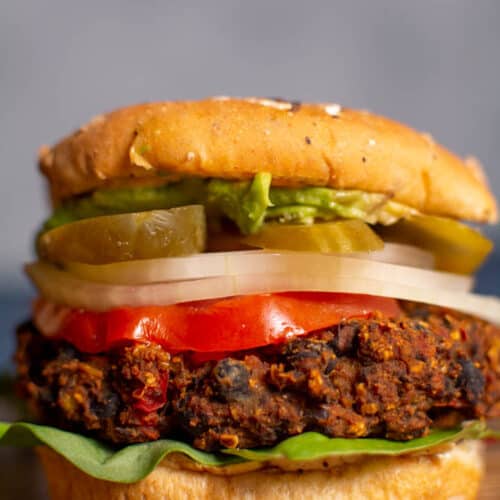 burger with black bean patty, lettuce, tomato, onion, pickles, and avocado