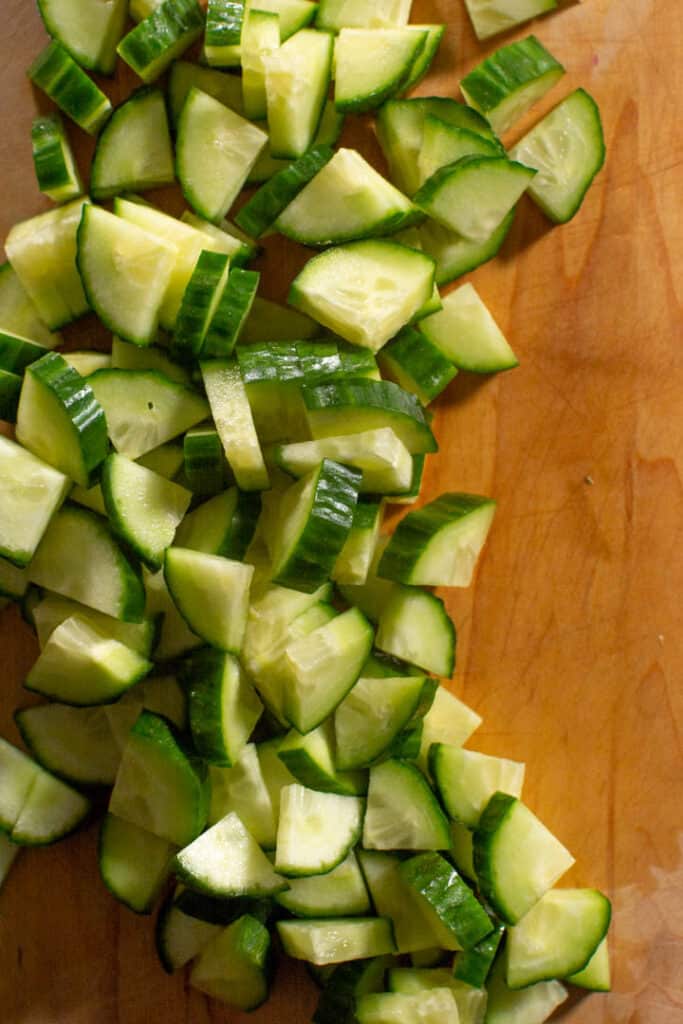Sliced and quartered cucumber on chopping block