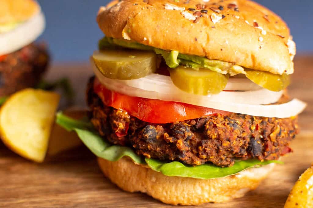 black bean burner on bun with lettuce, tomato, onion, pickles, and avocado