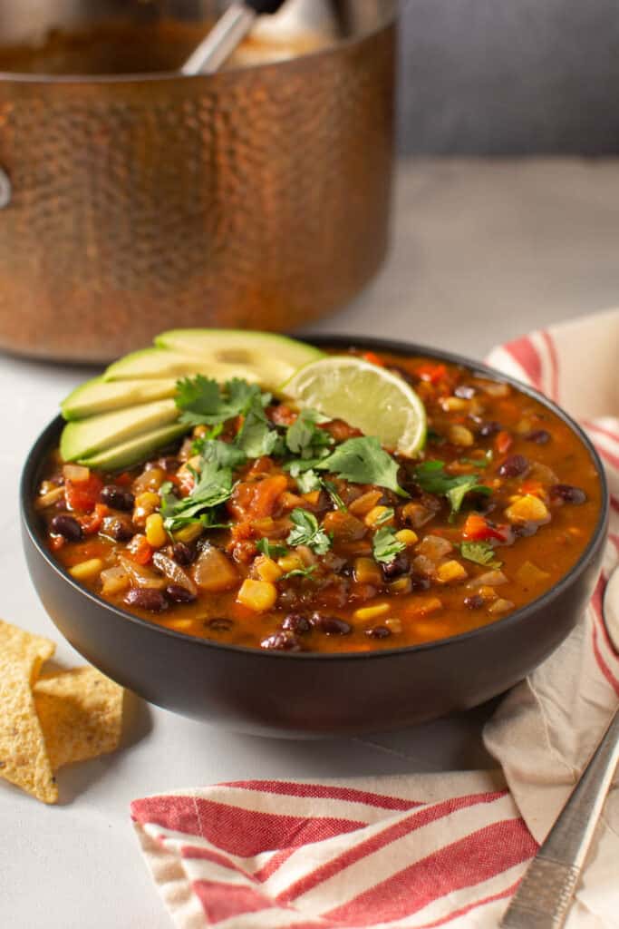 Bowl of soup with pot in the background