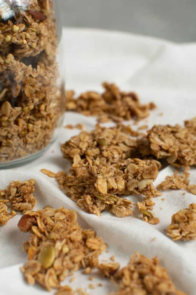 Jar of granola with close up of clumps