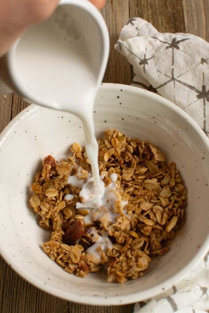 Pouring milk over bowl of granola