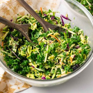 Salad in bowl with wooden serving utensils