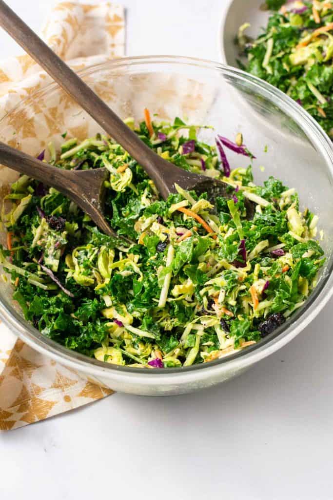 Salad in bowl with wooden serving utensils