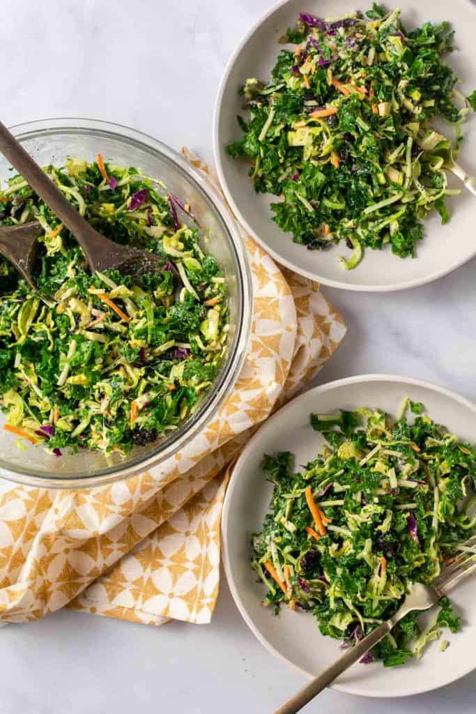 Over head shot of bowl of salad and two plates of salad.