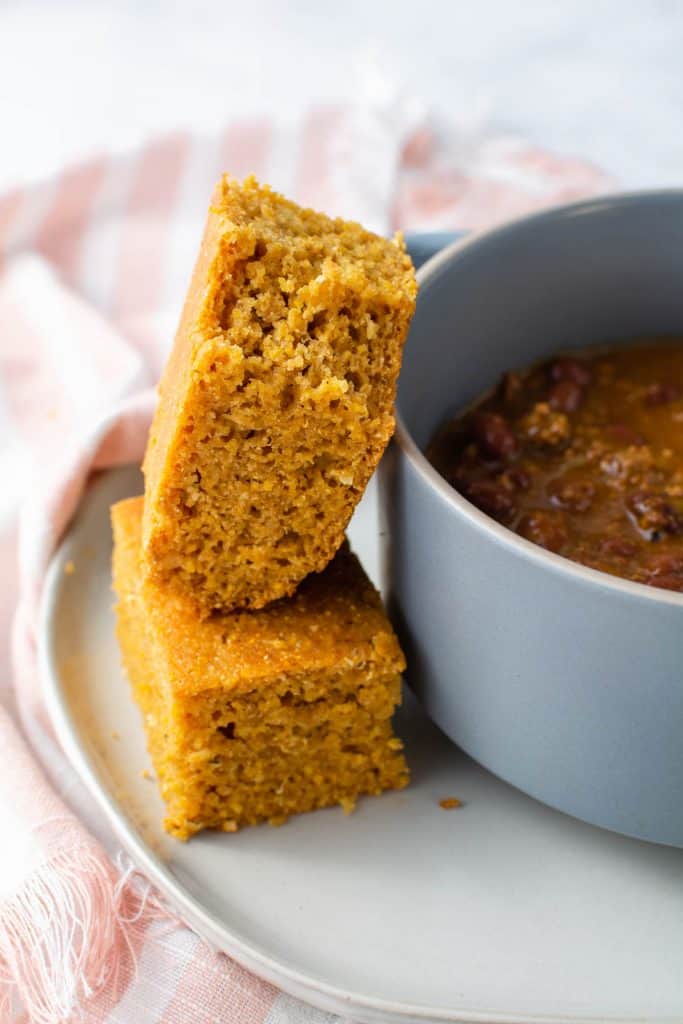 Cornbread next to a bowl of chili.