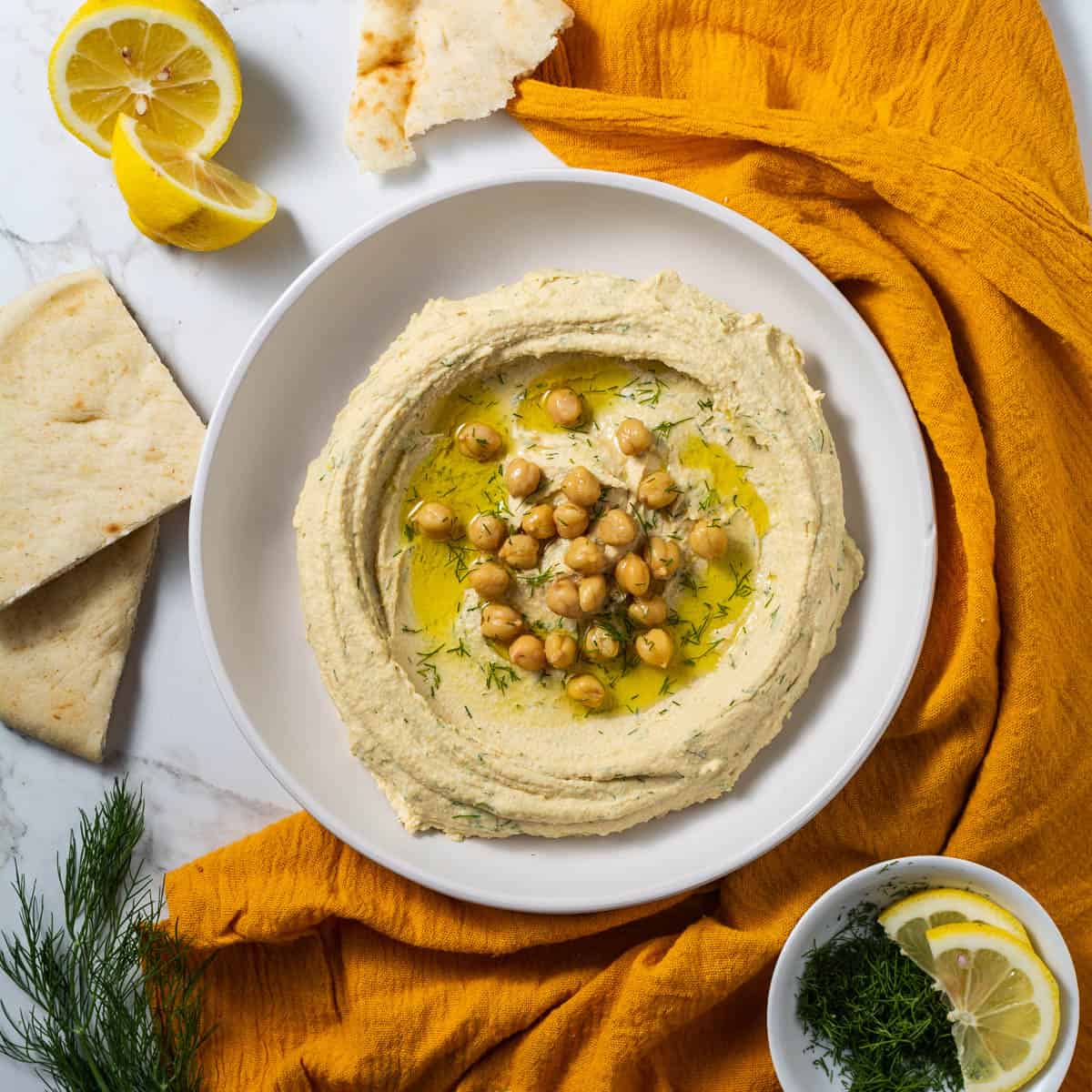Overhead shot of hummus being served on a plate with a drizzle of olive oil