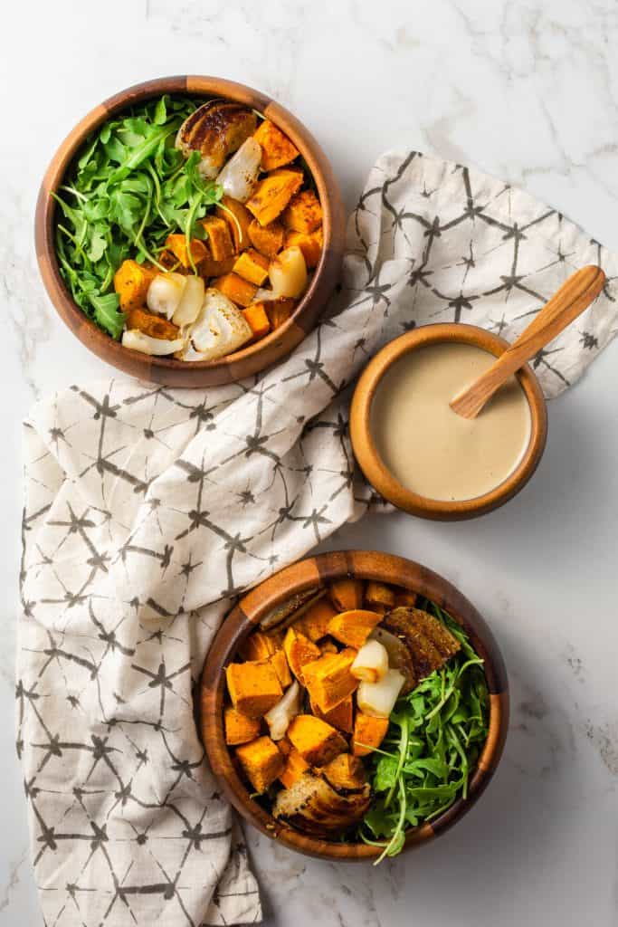 birdseye of two bowls of hash with a bowl of dressing.