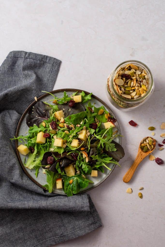 Overhead shot of salad and jar of salad topper mix.