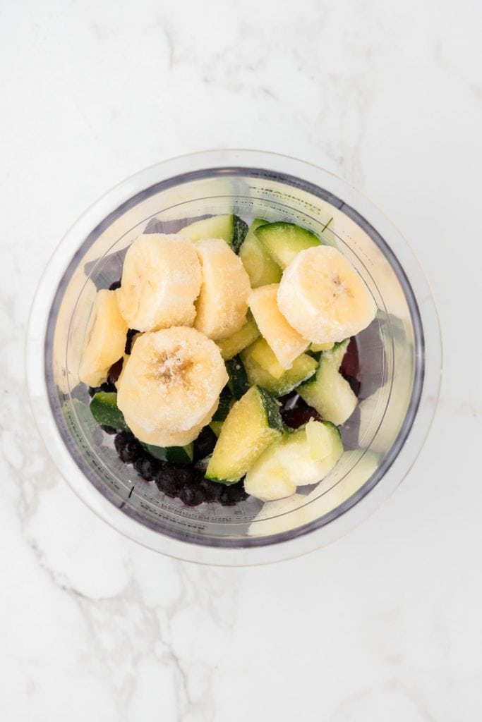 overhead shot of zucchini and banana added to the creami container.