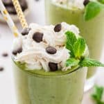 Close up of smoothie with whipped cream and chocolate chips on top.