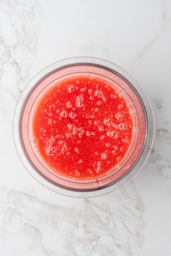 overhead shot of pint container full of blended ingredients for watermelon sorbet before freezing.