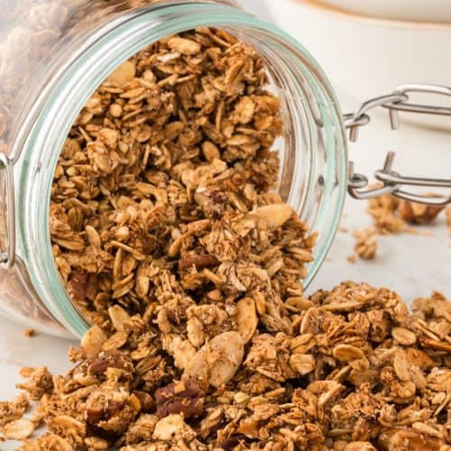 glass container on its side with granola spilling out.