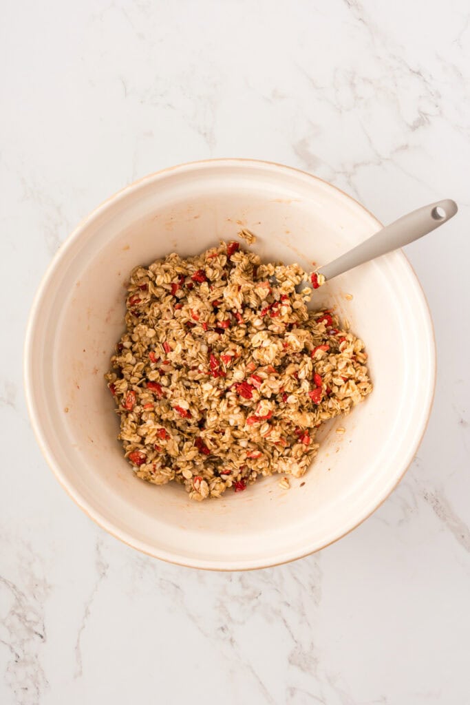 overhead shot of granola bar ingredients mixed together in a large bowl.