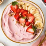 Overhead shot of smoothie in a bowl with fresh fruit on top.