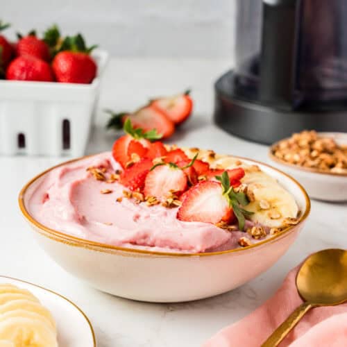 Bowl full of smoothie bowl with fresh fruit on top.