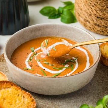 45 degree photo of soup in a bowl with spoon scooping a bite.